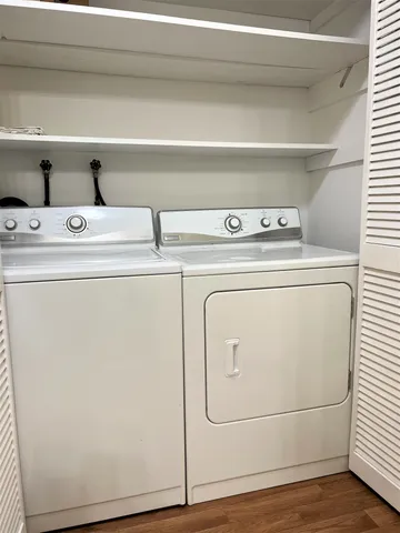 an empty room with a windows and chandelier fan