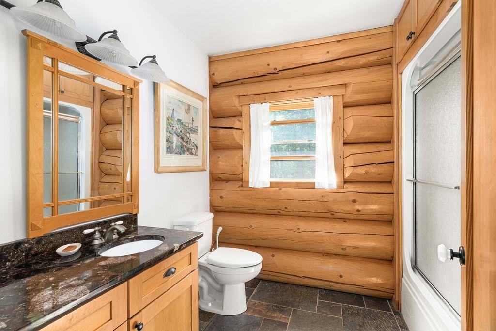 4015 East Van Road Duluth, MN 55803 - Photo 17 of 31 Bathroom featuring log walls, vanity, and stone tile floors