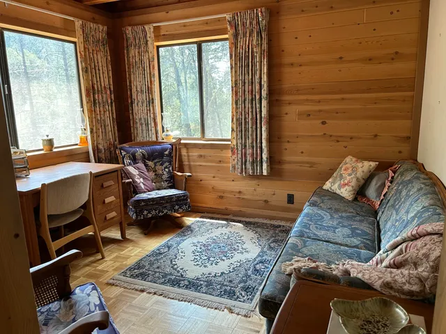 a living room with a large window and furniture
