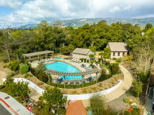 a view of a swimming pool with a yard and plants