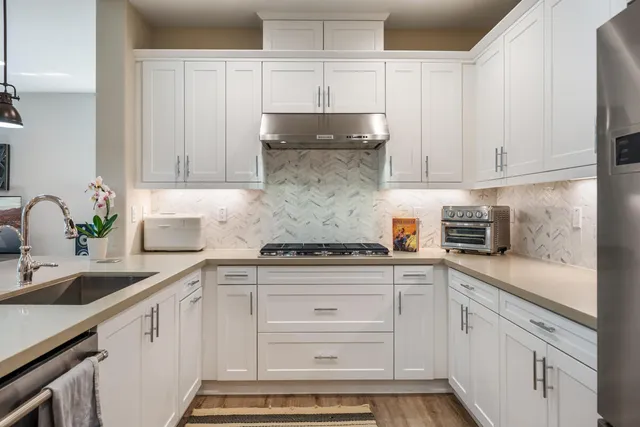 a kitchen with granite countertop white cabinets and white appliances