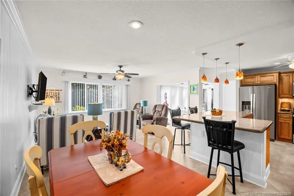 a living room with furniture a large window and kitchen view