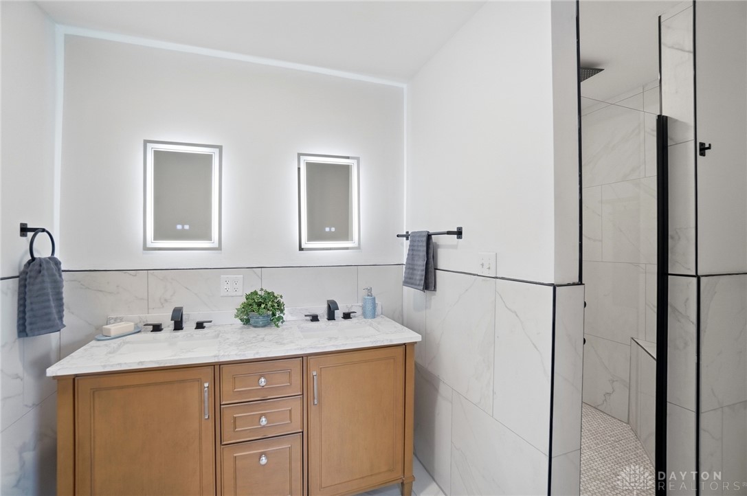 25 Englewood Road Springfield, OH 45504 - Photo 24 of 66 This primary bathroom features a dual vanity with elegant fixtures and a modern shower enclosure.
