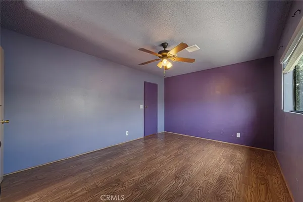 an empty room with a window and a chandelier