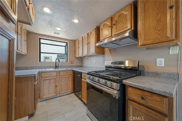 a kitchen with stainless steel appliances granite countertop a stove and a sink