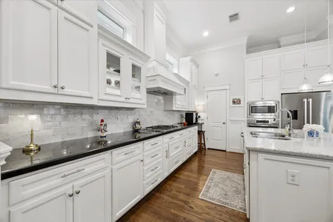 a large kitchen with stainless steel appliances granite countertop a lot of counter space and wooden cabinets