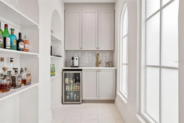 a kitchen with white cabinets and window