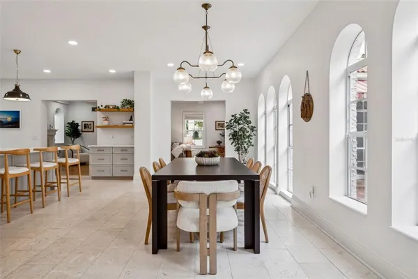 a dining room with furniture a chandelier and window