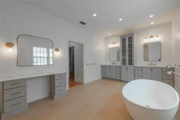 a bathroom with a double vanity sink mirror and bathtub