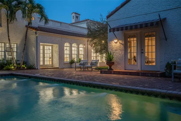 a view of a house with swimming pool next to a yard