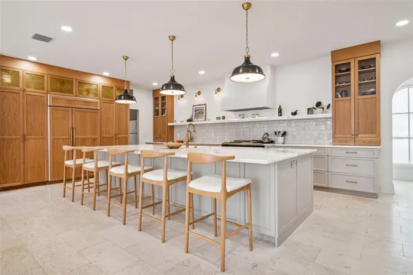 a kitchen with stainless steel appliances kitchen island granite countertop a stove a sink a dining table and chairs