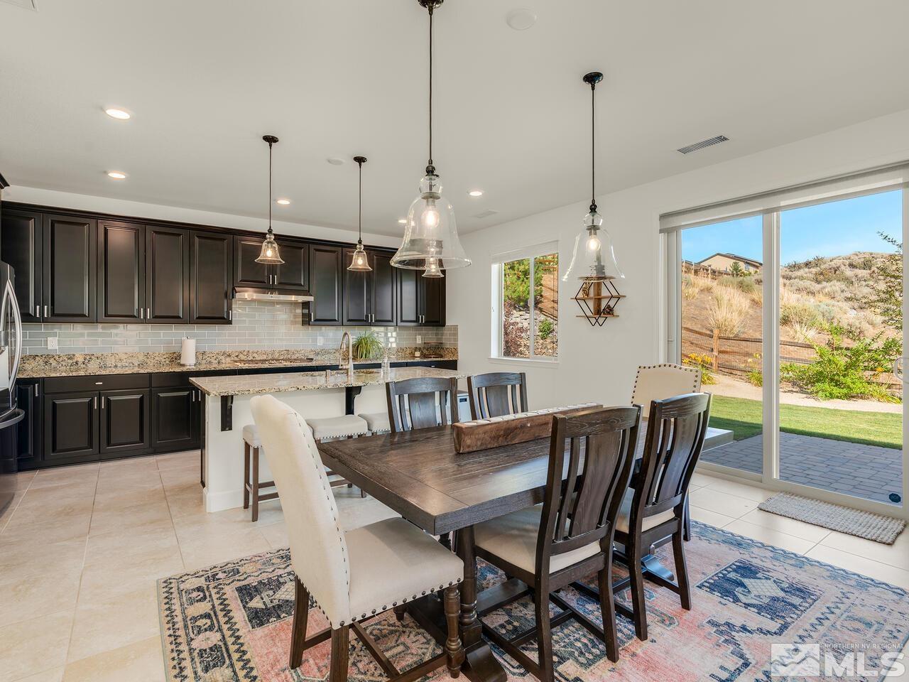 1770 Scott Valley Road Reno, NV 89523 - Photo 8 of 29 a kitchen with stainless steel appliances granite countertop a stove a refrigerator a kitchen island a dining table and chairs