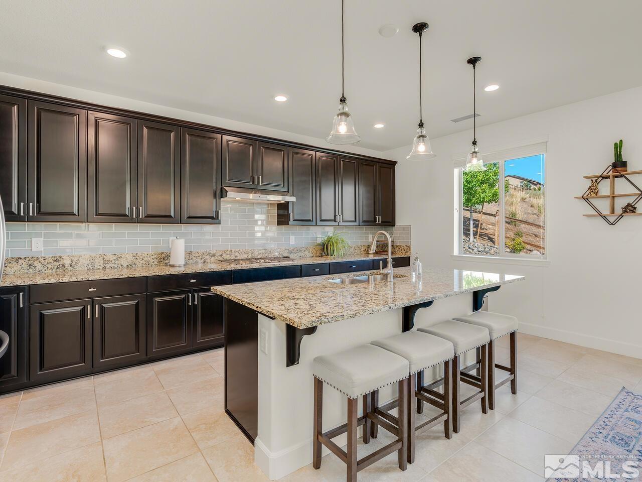1770 Scott Valley Road Reno, NV 89523 - Photo 9 of 29 a kitchen with granite countertop wooden cabinets a center island and appliances