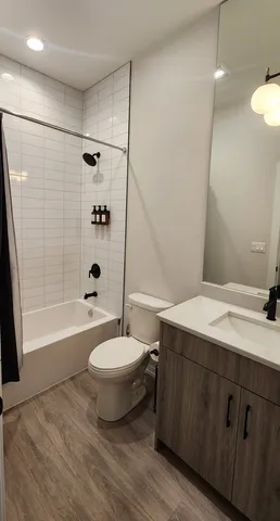 a bathroom with a sink a toilet a mirror a bathtub and shower