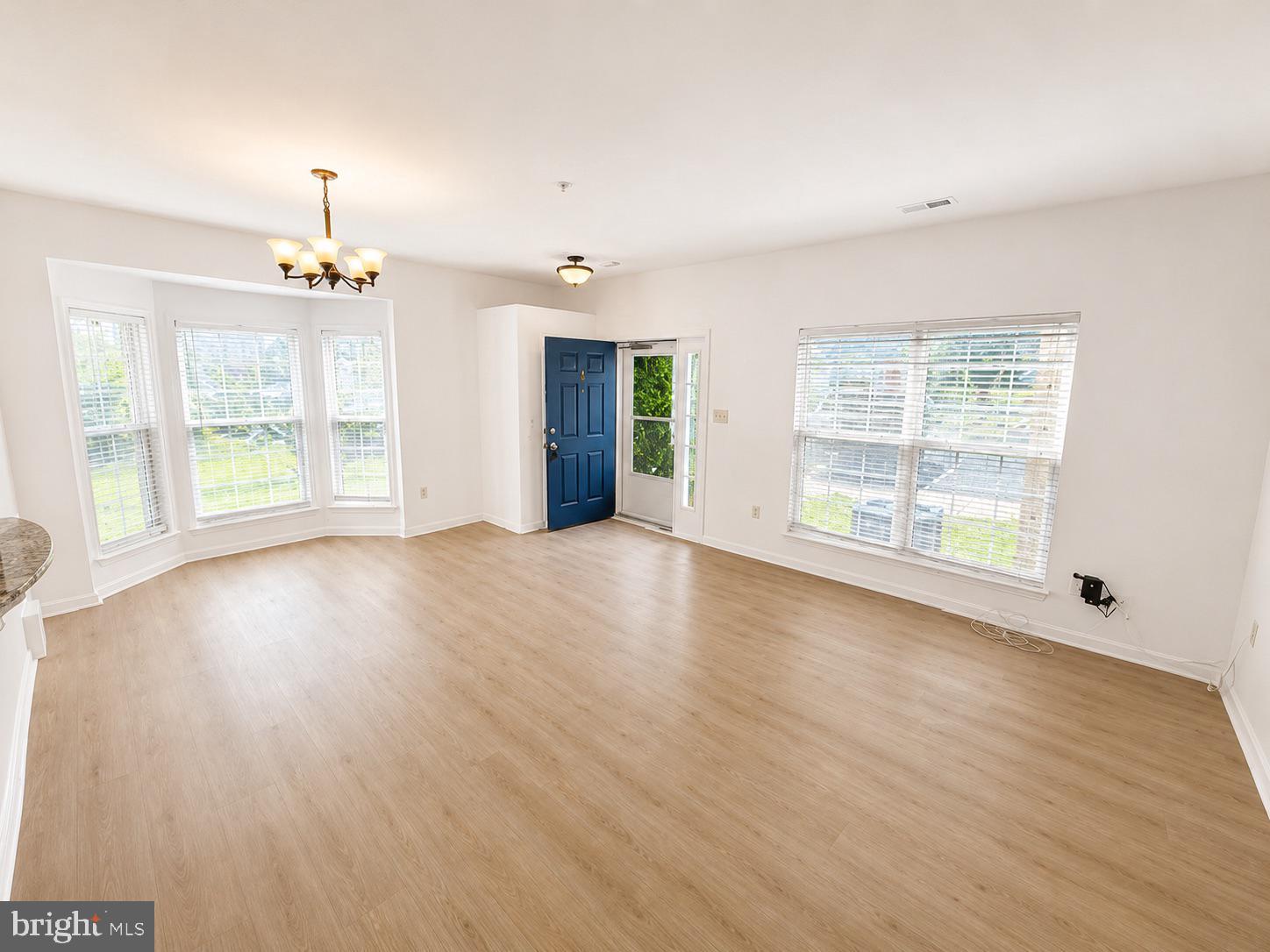 308 Assembly Point Court Odenton, MD 21113 - Photo 4 of 19 a view of an empty room with wooden floor and a window