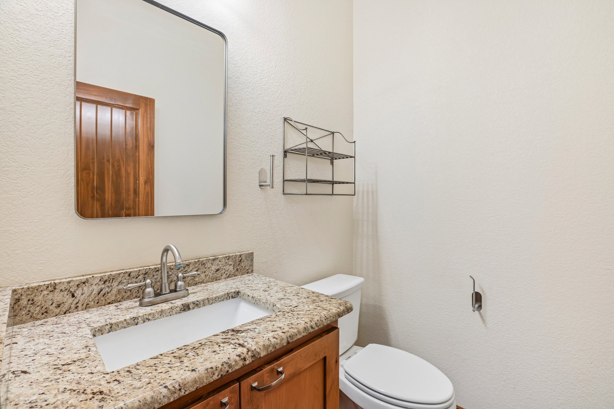 267 Corral Road Smithville, TX 78957 - Photo 26 of 40 Bathroom vanity featuring a speckled countertop, undermount sink, and brushed nickel faucet