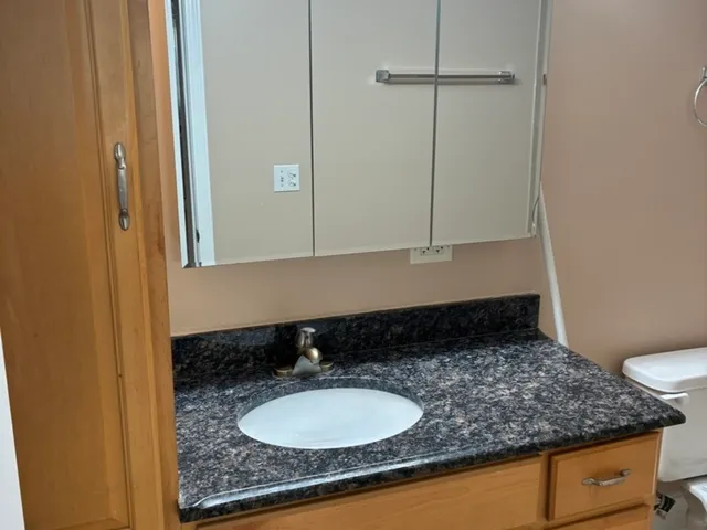 a bathroom with a granite countertop sink and a mirror