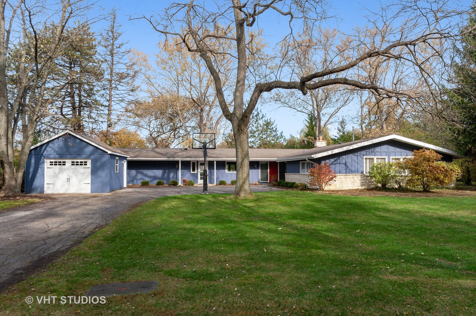 a view of a yard in front of a house with large trees