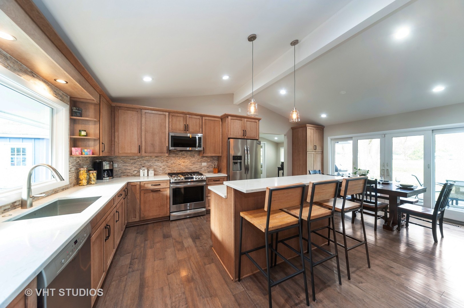 1555 Tower Road Winnetka, IL 60093 - Photo 8 of 27 a kitchen with stainless steel appliances granite countertop a stove top oven a sink dishwasher a dining table and chairs with wooden floor