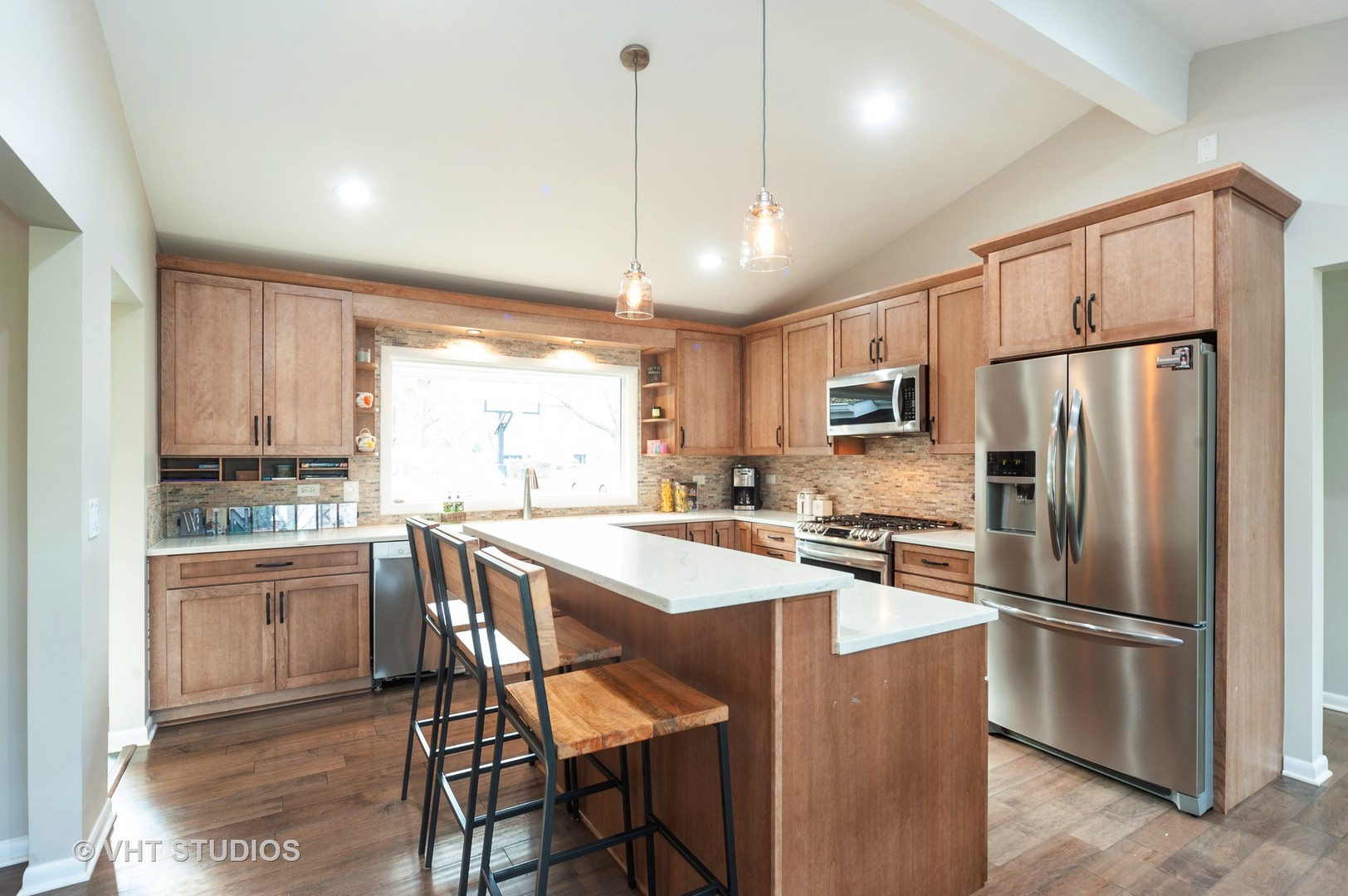 1555 Tower Road Winnetka, IL 60093 - Photo 9 of 27 a kitchen with stainless steel appliances granite countertop a refrigerator a sink a stove a dining table and chairs