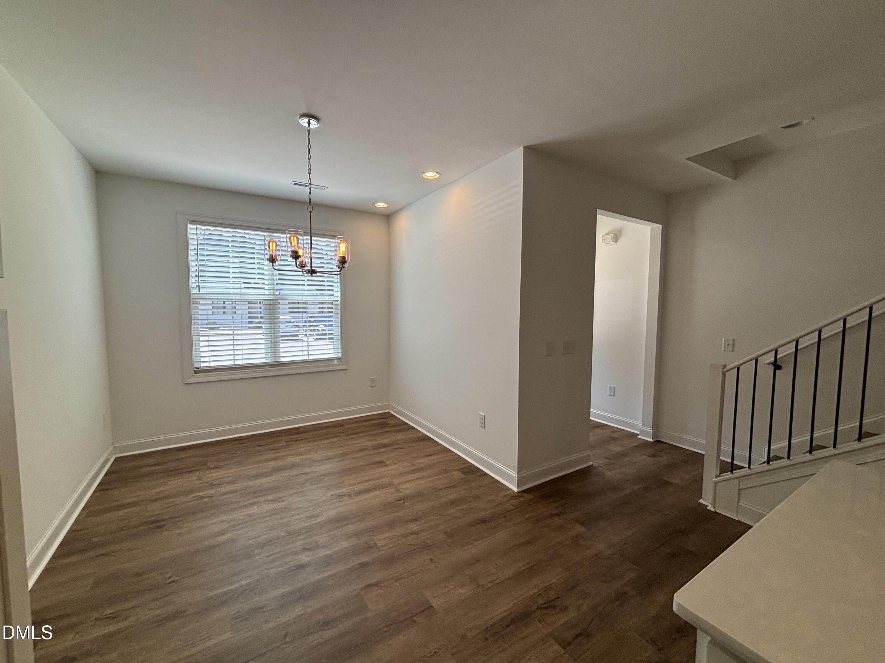 5710 Parker Pnes Court Raleigh, NC 27609 - Photo 3 of 78 an empty room with wooden floor chandelier and entryway