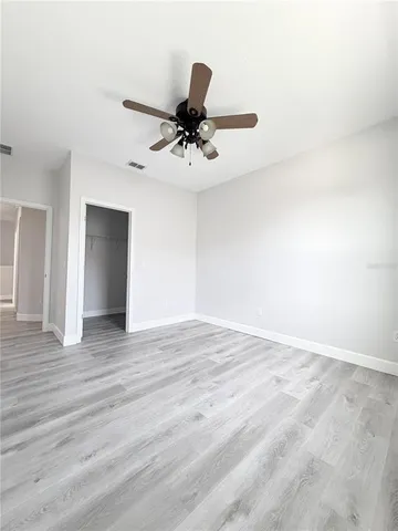 a view of a room with wooden floor and ceiling fan
