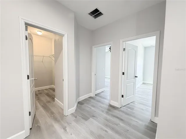 a view of a bathroom with wooden floor and mirror