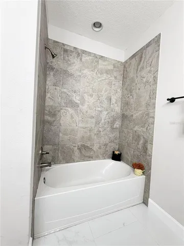 a bathroom with a bathtub and shower