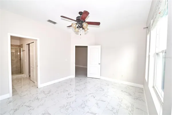 a view of an empty room with wooden floor and closet