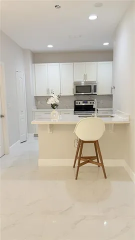 a kitchen with kitchen island a stove a table and chairs in it