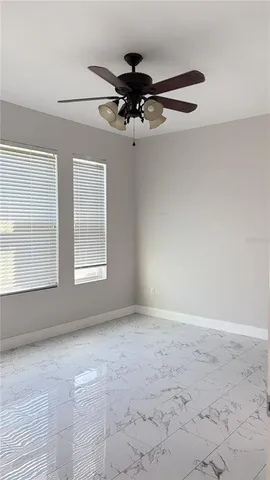 en empty room with windows and ceiling fan