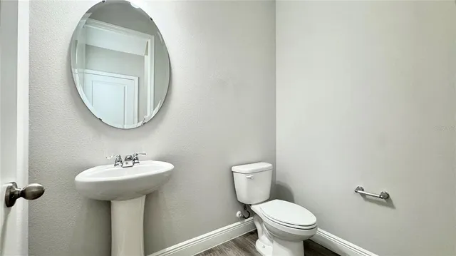 a large kitchen with kitchen island a stove a sink dishwasher a refrigerator white cabinets and wooden floor