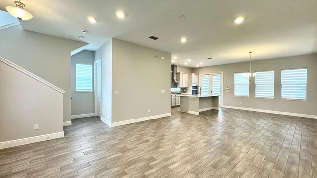 a view of an empty room with window and a ceiling fan
