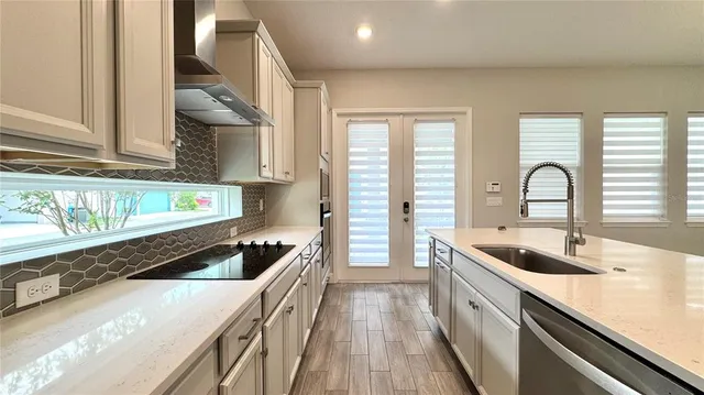 a kitchen with stainless steel appliances granite countertop a sink and a stove