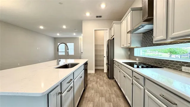 a kitchen with granite countertop a refrigerator and a sink