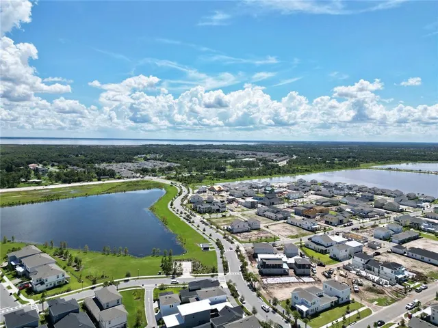 an aerial view of a city with lots of residential buildings ocean and mountain view in back