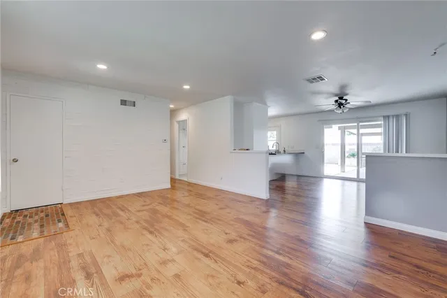 a view of empty room with wooden floor and windows