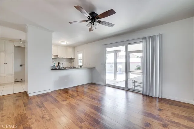 a view of an empty room with a window and wooden floor