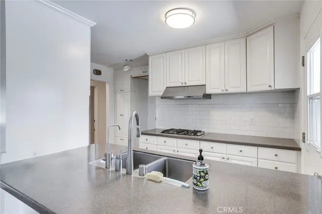 a kitchen with stainless steel appliances granite countertop a lot of cabinets a stove and a sink