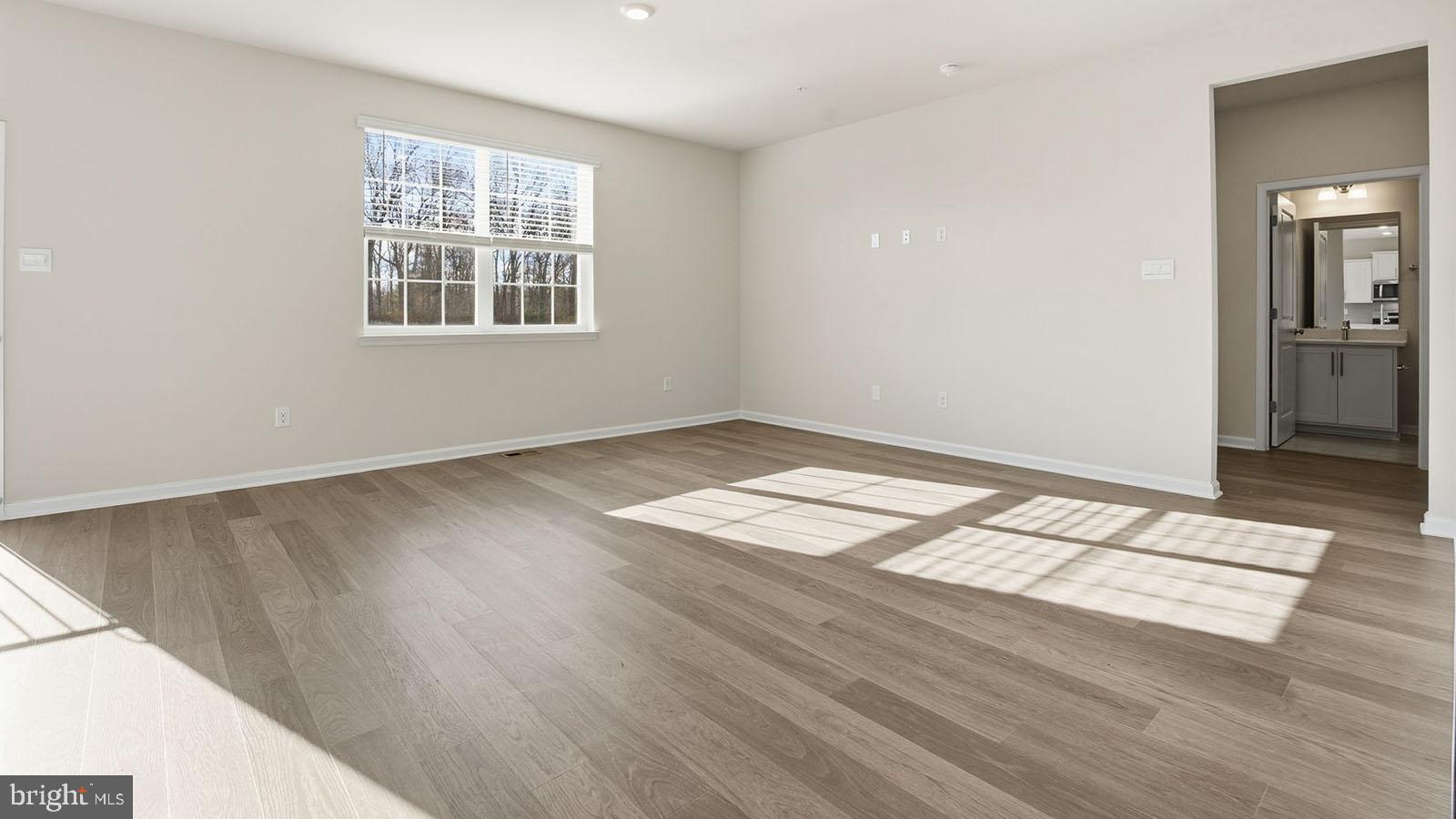 8110 Cypress Pt Drive Rosedale, MD 21237 - Photo 3 of 37 an empty room with wooden floor windows and cabinet
