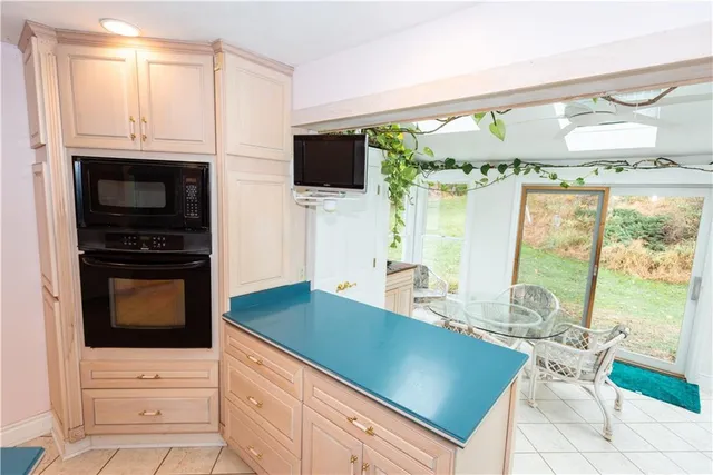 a kitchen with stainless steel appliances granite countertop a stove a refrigerator a microwave oven with white cabinets and wooden floor