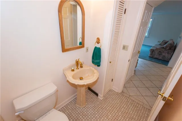 a bathroom with a toilet sink and mirror