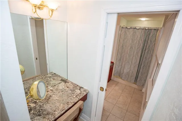 a bathroom with a granite countertop shower and mirror