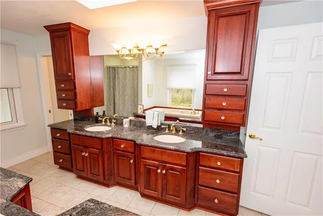 a spacious bathroom with a granite countertop double vanity sink and mirror