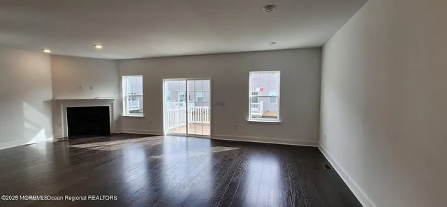an empty room with wooden floor and fireplace