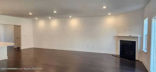 an empty room with wooden floor and entrance