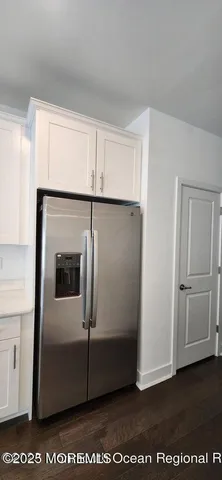 an empty room with wooden floor and entrance