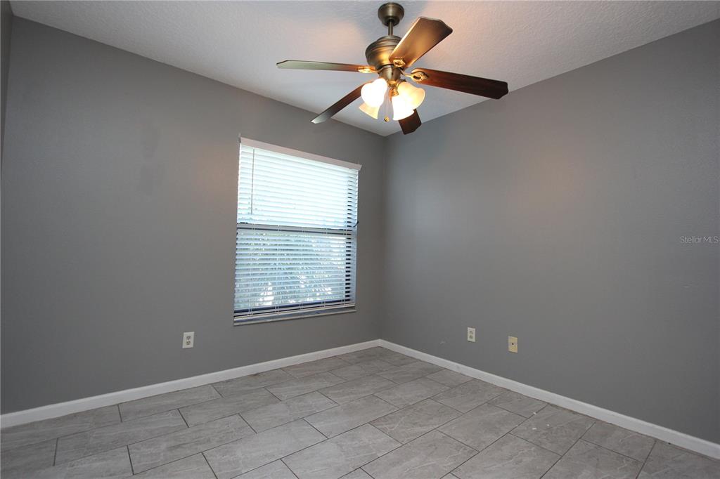 1131 South Pine Ridge Circle, Unit 1 Sanford, FL 32773 - Photo 17 of 19 an empty room with chandelier fan and windows