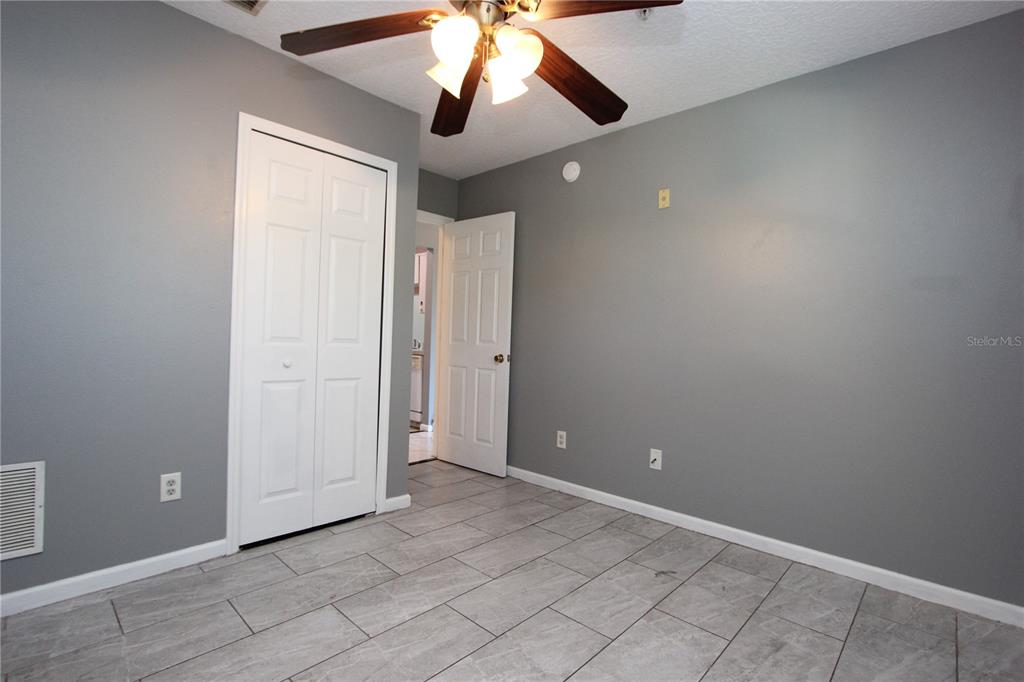 1131 South Pine Ridge Circle, Unit 1 Sanford, FL 32773 - Photo 18 of 19 an empty room with chandelier fan and windows