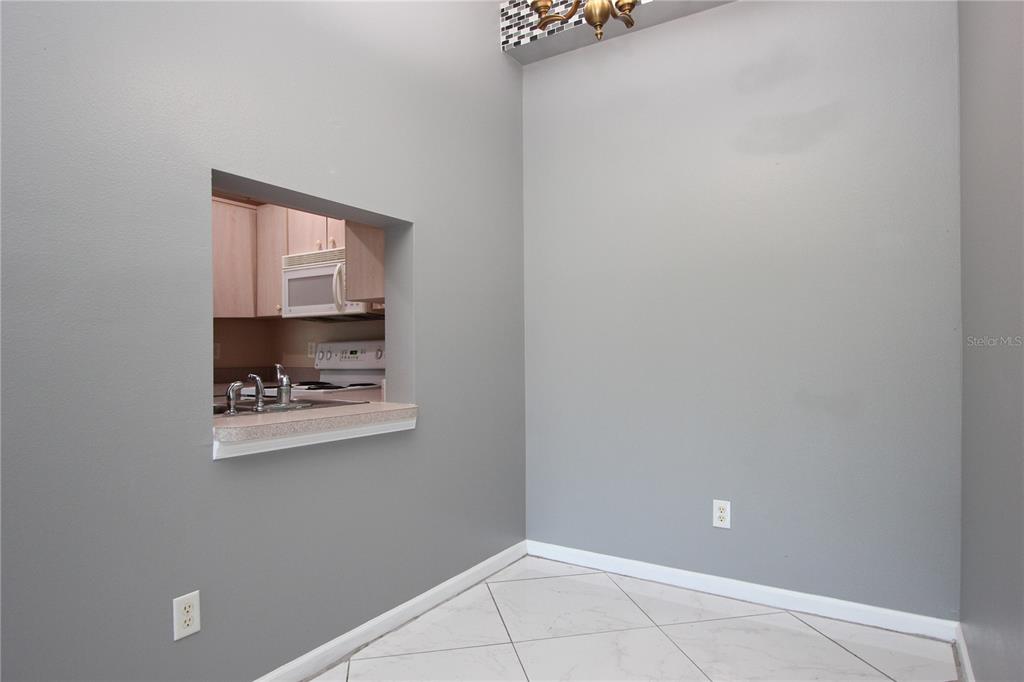 1131 South Pine Ridge Circle, Unit 1 Sanford, FL 32773 - Photo 7 of 19 a room with a white wall and a potted plant